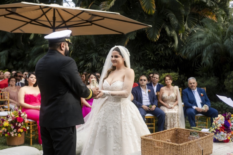 Los novios se toman las manos con el costalito de la abundancia